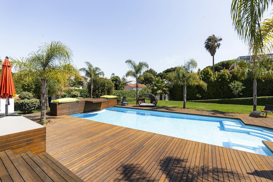 Wood pool deck in a sunny backyard